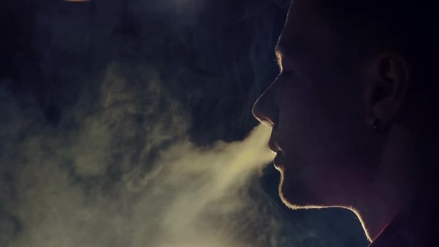 Young man smoking hookah in a bar