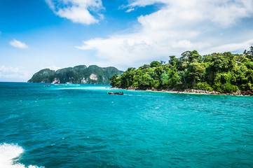 Fototapeta premium Small wooden boat near the island in the ocean