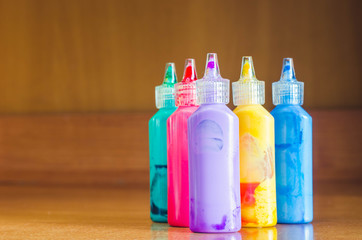 Color tubes with a paint on a wood background,