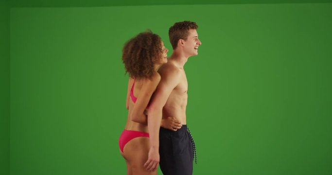 Portrait of young attractive millennial couple holding each other the beach on green screen. On green screen to be keyed or composited. 