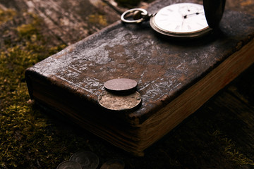 Pocket watch with old antique bible book and retro coins
