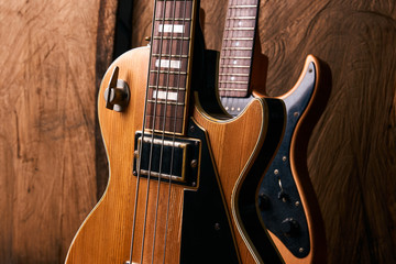 Fototapeta na wymiar Wooden electric bass guitar and classic electric guitar