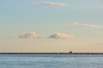 Fototapeta premium Conceptual image: a group of children crossing a bridge over the sea.