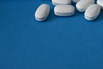 White pills on a blue background