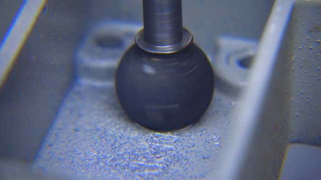The countersink turns and grinds the edge of the hole in the metal part. Shavings are flying around. Macro. Closeup. Slow mo, slo mo, slow motion, high speed camera, 240fps, 250fps