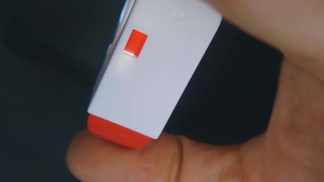 The hand presses the button and the sugar substitute tablet drops out of the box and falls down into a cup of tea. Macro. Closeup. Slow motion, high speed camera, 240fps, 250fps