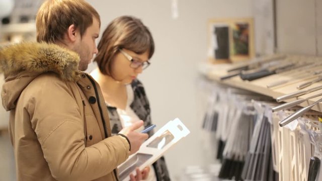 Young couple are choosing crockery at shop