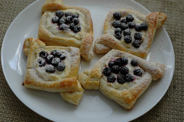 Slices in the form of diamonds with blueberries on a white plate.