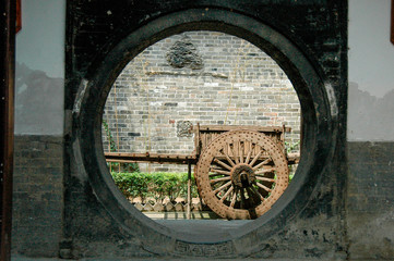 A round door and an old cart in the garden of Xian Painting School, China