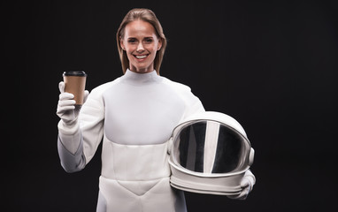 Need some energy. Waist-up portrait of positive young attractive woman astronaut is standing and...