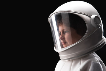 Close-up side view of head of little astronaut wearing white helmet and standing while looking aside dreamily. Isolated background with copy space in the left side © Yakobchuk Olena