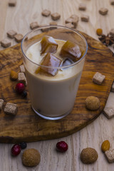 Milk with coffee ice cubes on a wooden table