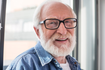 Happy retirement. Close up portrait of senior smiling pensioner looking at camera