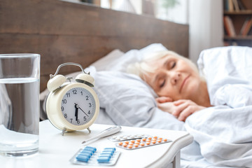 Senior woman resting at home sleeping in bed elderly lifestyle