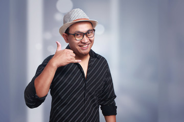 Young Man Wearing Havana Hat Smiling Asking to Call Gesture