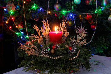 Christmas decoration with fresh tree branches, cones and red candle. Christmas composition. Christmas arrangement with candle. 
