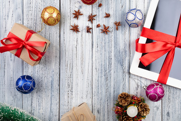 Presents wrapped with red ribbon and new year's attributes on vintage wooden background