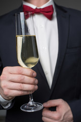 Close up of gentleman arm keeping glass of wine with bubbles