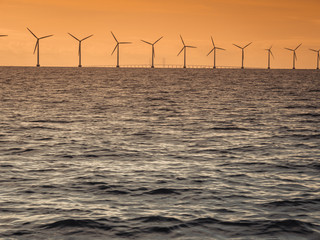 Wind turbines power generator farm along coast sea