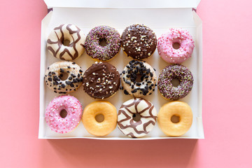 Box of fancy donuts with sprinkles on pink background - 184960983