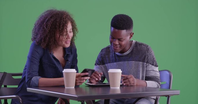 Young African American couple have coffee on green screen. On green screen to be keyed or composited. 