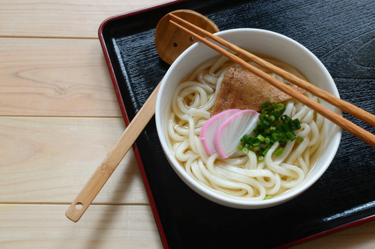 A Bowl Of Udon Noodles Topped With Fried Seasoned Tofu Skin