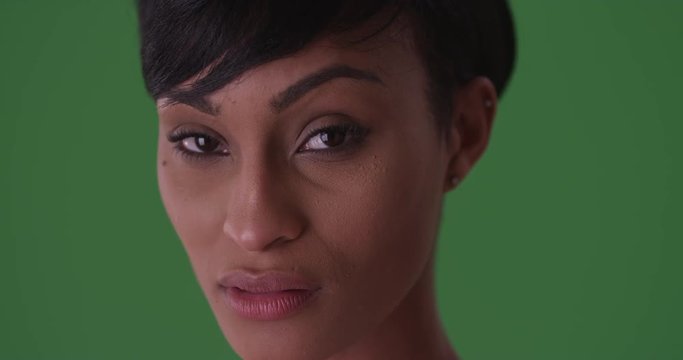 Close-up portrait of a young black woman with a serious face on green screen. On green screen to be keyed or composited. 