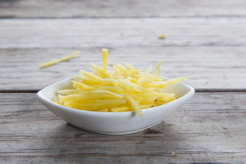 Ginger cut into strips on wooden table