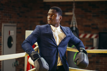 African businessman standing posture in boxing gloves in the Boxing ring.