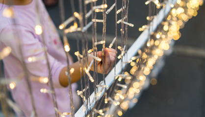 Hand of kid touching starry lighting chain hanging