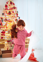 cute happy toddler boy in pajamas has got his present on christmas