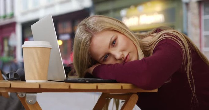 Stunning Caucasian beauty resting from work looks at camera mesmerizingly 