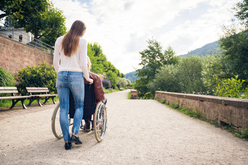 Young Couple In Wheelchair Strolling In The Park