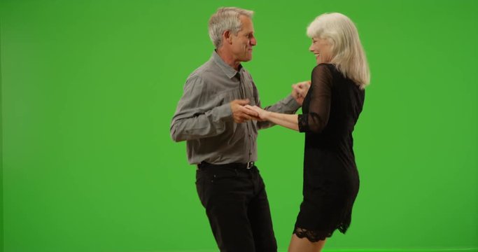 Sweet senior couple dancing together on green screen. On green screen to be keyed or composited. 