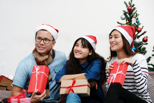 Young asia man and women holding gift boxes with happiness in Christmas party, friends Christmas party celebration