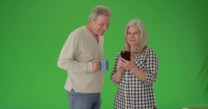 Elderly white couple reading a cellphone