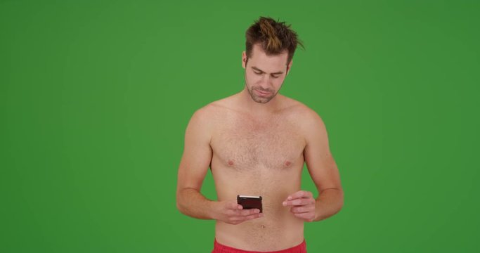 Yuccie man using dating app on his phone on green screen. On green screen to be keyed or composited. 
