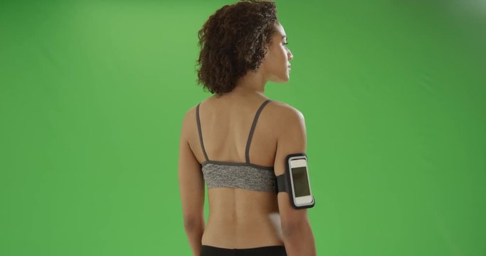 An african American female runner looks off in the distance on green screen. On green screen to be keyed or composited.