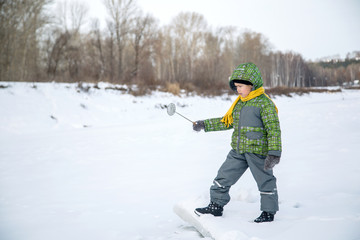 Fototapeta premium boy holding a bucket for ice fishing