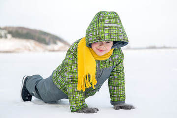 boy doing exercise push-UPS on the ice on the lake