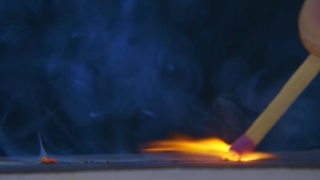 The match in the hand moves on the side of the matchbox and light the fire. S-log - High Dynamic Range. Macro. Slow mo, slo mo, slow motion, high speed camera, 240fps, 250fps