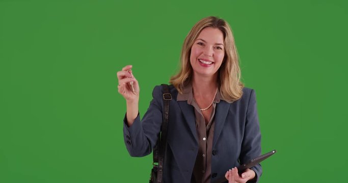 Middle aged Caucasian female realtor selling home on green screen. On green screen to be keyed or composited.