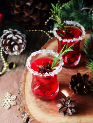 glass of hot mulled wine for the new year with ingredients for cooking, nuts and Christmas decorations