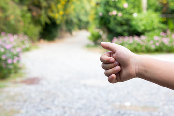 Asian boy show thumb up with blurred way background (Concept for hitch hiking, good work, like)