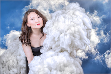 Asian woman holds the clouds in her hands as a concept of managing natural phenomena.