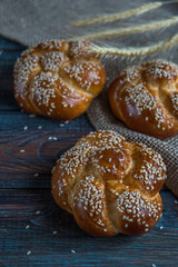 Buns with sesame seeds on a wooden background top view