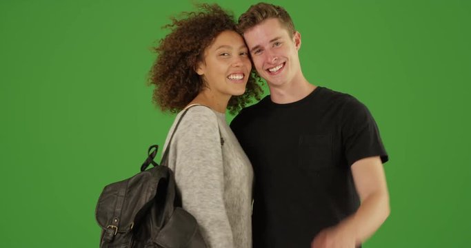 Portrait of Happy Millennial couple standing outside together smiling at camera on green screen. On green screen to be keyed or composited. 