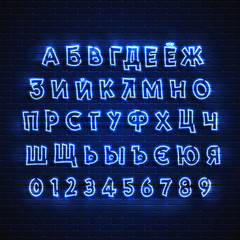 Fototapeta premium Russian neon font. Glowing alphabet, electric stand, against a brick wall background, Electric Abc..