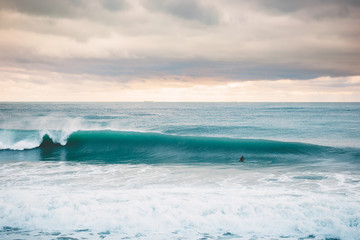 A Perfect big breaking Ocean barrel wave and surfer