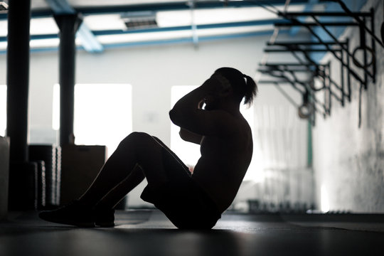 silhouette of Muscular man exercising doing sit up exercise. Athlete with six pack, white male, no shirt